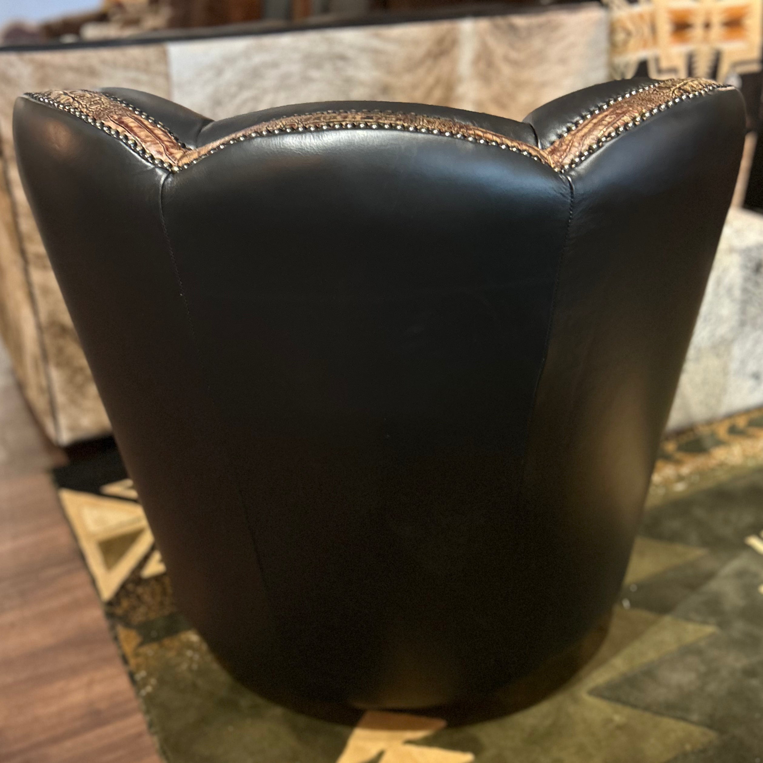 Black leather swivel glider armchair with embossed crocodile accents and nailheads.