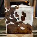 Cube ottoman with cowhide pattern on a patterned rug