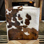 Cube ottoman with cowhide pattern on a patterned rug