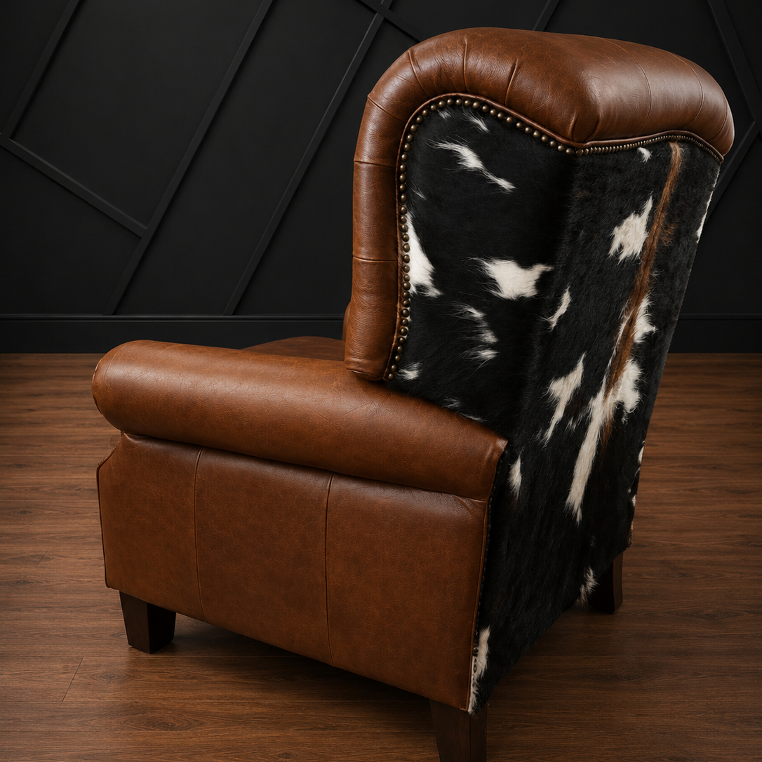 Recliner with brown leather and black and white cowhide against a dark geometric wall.