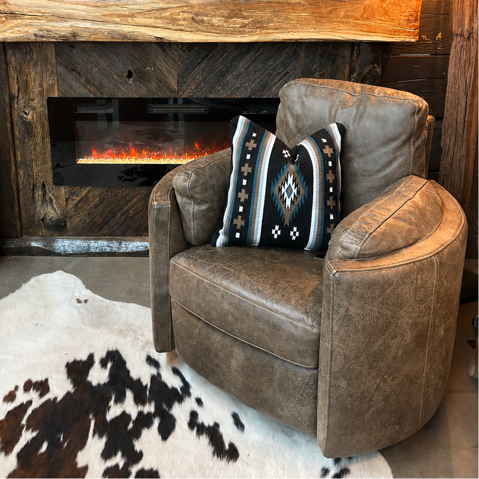Grey leather recliner in front of rustic fireplace.