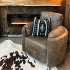 Grey leather recliner in front of rustic fireplace.