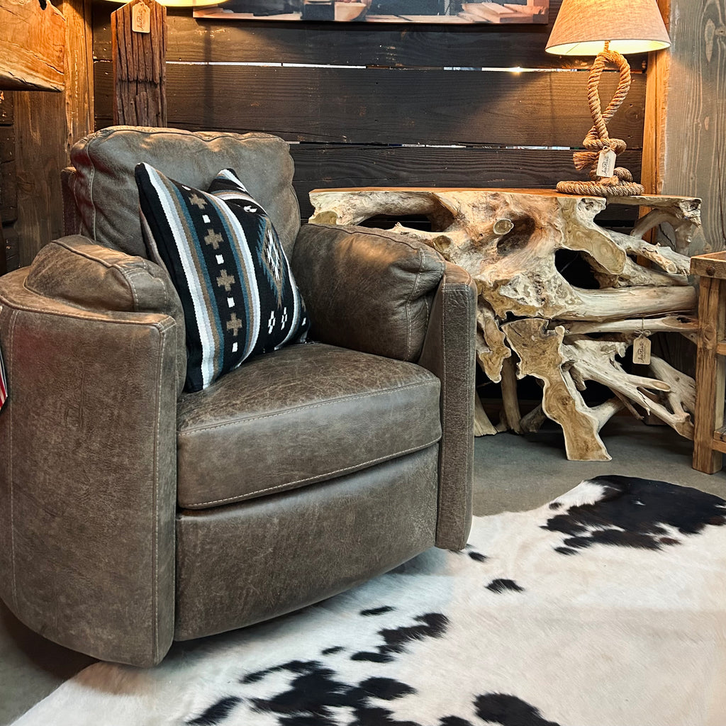 Grey leather recliner in front of teak root table.