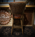 Brown leather barstool with button tufting and cowboy tooled leather.