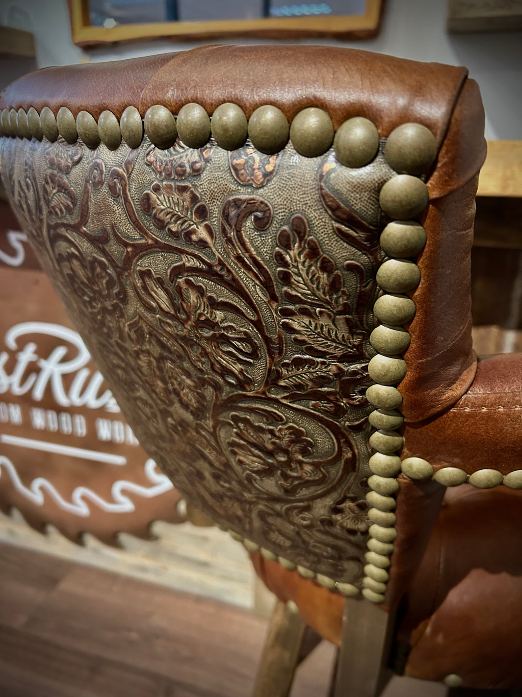 Brown leather barstool with button tufting and cowboy tooled leather.