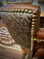 Brown leather barstool with button tufting and cowboy tooled leather.
