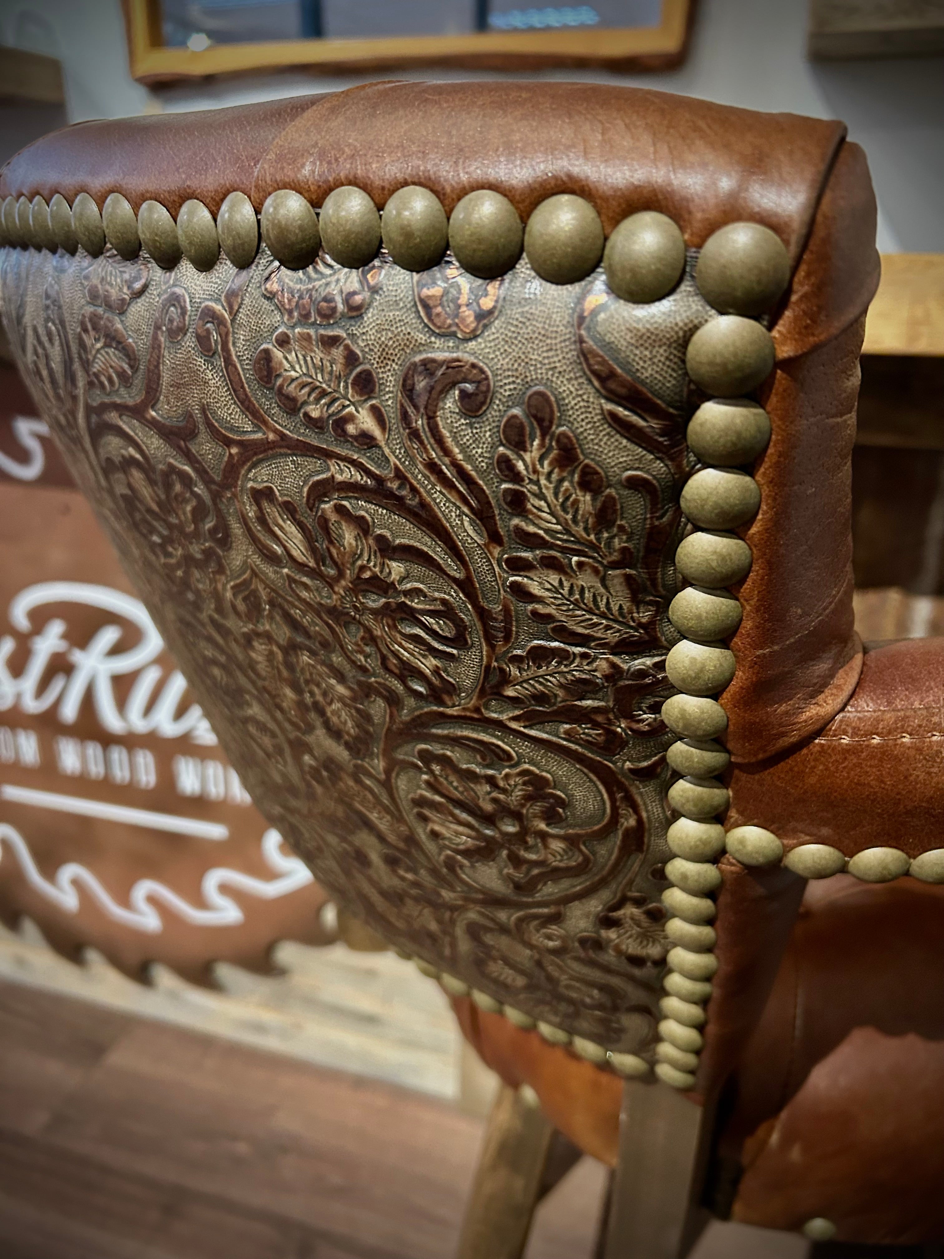 Brown leather barstool with button tufting and cowboy tooled leather.