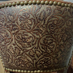 Brown leather barstool with button tufting and cowboy tooled leather.