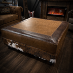 Brown leather ottoman with cowhide pattern in a cozy room with a fireplace.