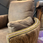 Brown leather recliner with cowhide arms and back.