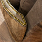 Brown leather recliner with brass neailheads and cowhide arms and back.