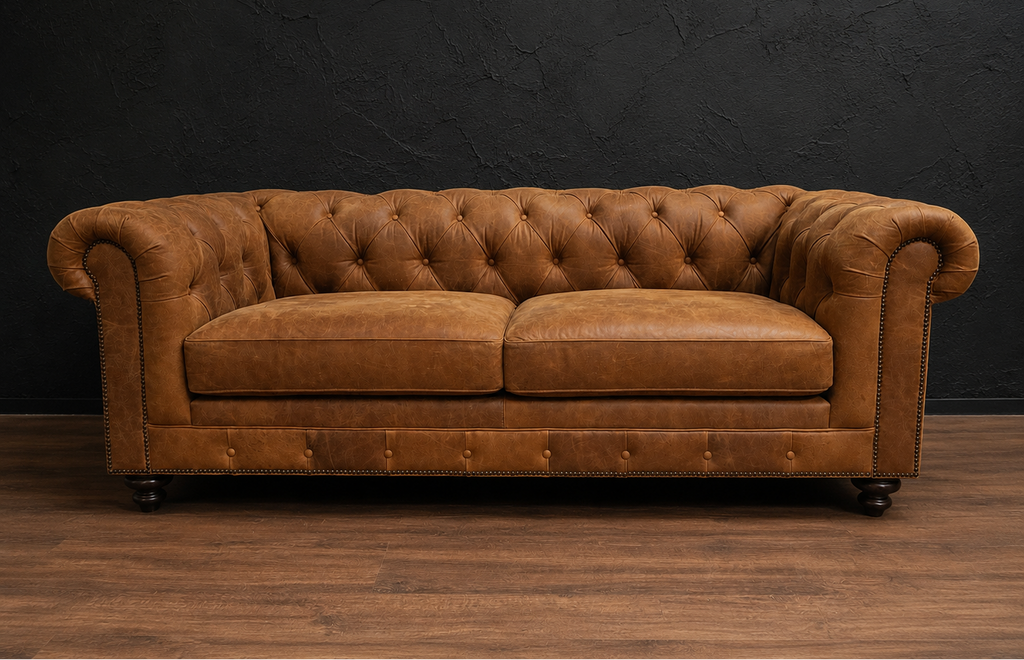 Brown leather sofa against a dark wall on a wooden floor