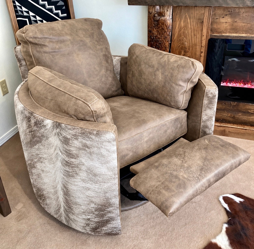 A gray recliner chair with a matching footrest extended, set in a home interior near a fireplace and wood mantel.