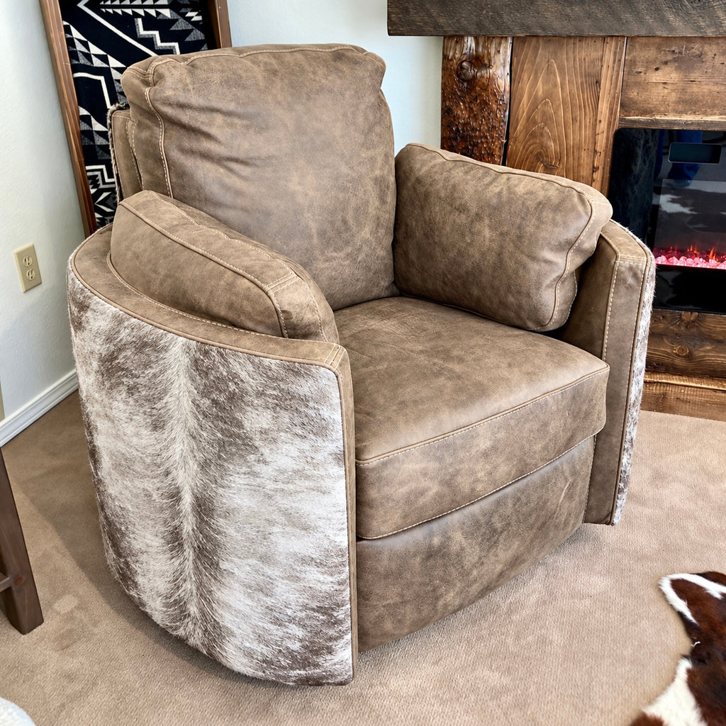 A gray leather swivel recliner chair with matching back and arm cushions, shown in a home setting next to a fireplace.