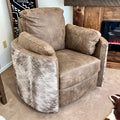 A gray leather swivel recliner chair with matching back and arm cushions, shown in a home setting next to a fireplace.