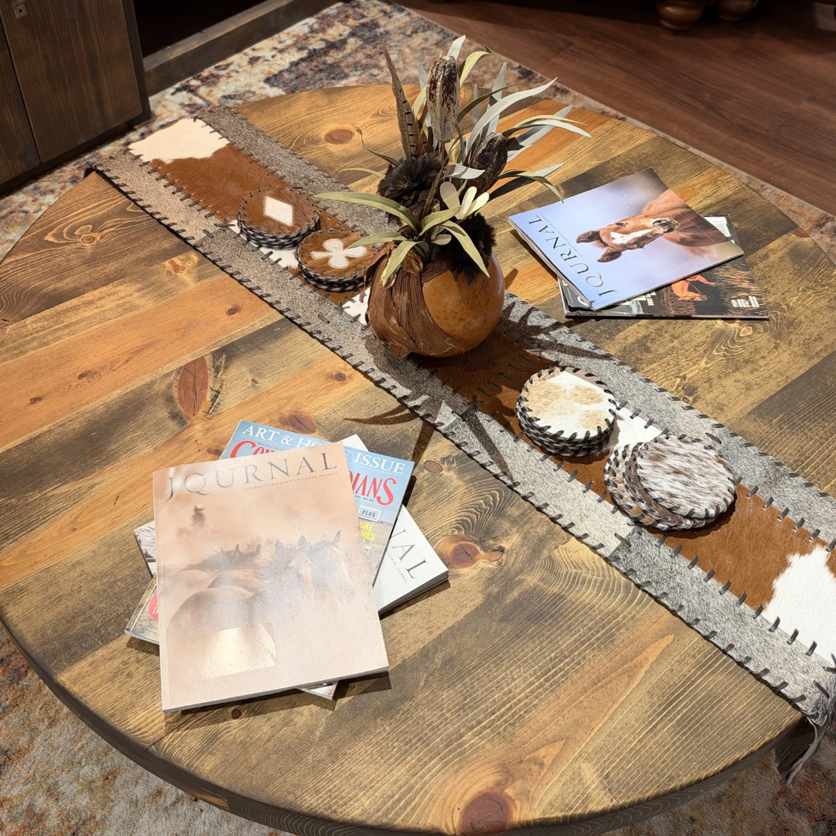 Chestnut Cowhide Table Runner styled diagonally across a round wood table
