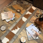 Chestnut Cowhide Table Runner with brown and white panels, contrasting border, leather lacing, and fringe