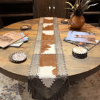 Overhead detail of chestnut brown and creamy white cowhide panels with dark leather lacing