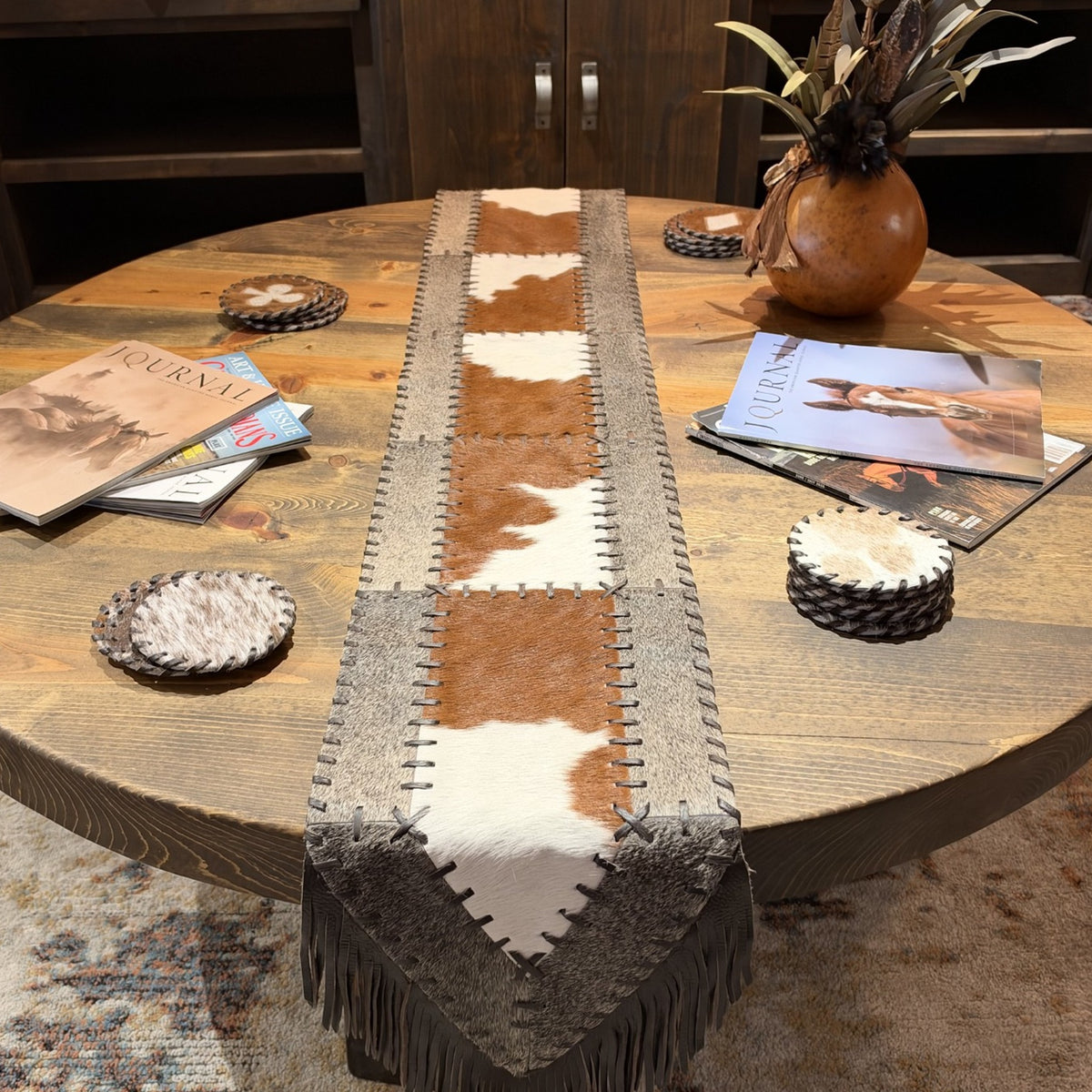 Overhead detail of chestnut brown and creamy white cowhide panels with dark leather lacing