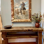 Head 'Em Up painting displayed above a rustic wood console