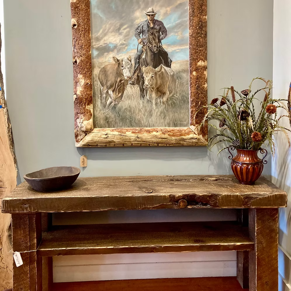 Head 'Em Up painting displayed above a rustic wood console