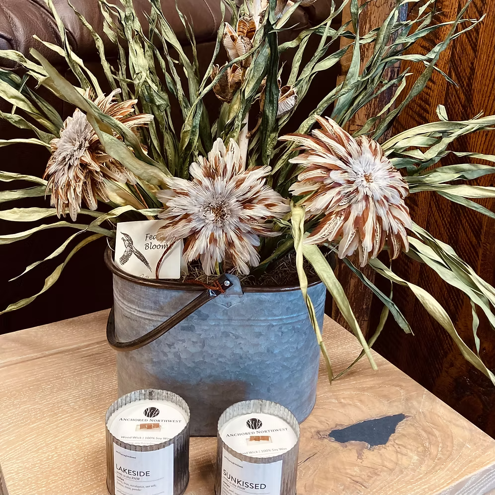Close-up of pale and brown Feather Bloom flowers arranged in a rustic tin pail
