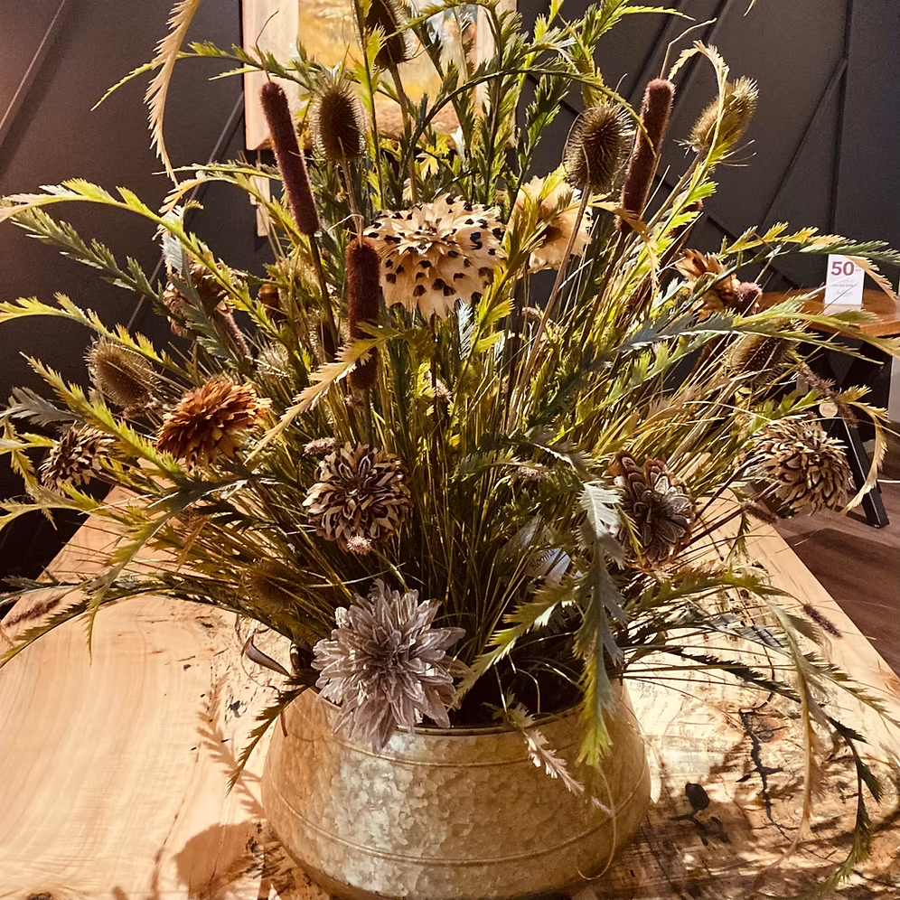 Fourteen-bloom Feather Bloom arrangement with sweeping greenery and a gold-colored vase